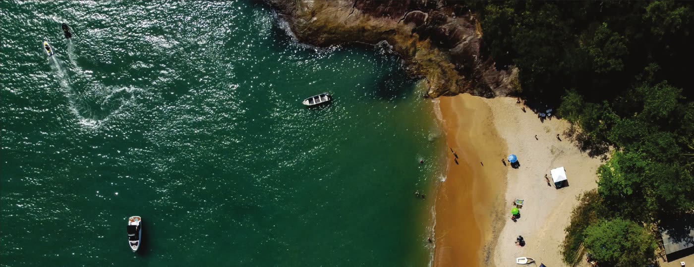 Vista aérea de praia de mar verde e areia dourada no litoral norte de São Paulo